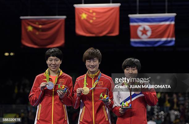 China's Ding Ning with her gold medal, her compatriot Li Xiaoxia with the silver medal and North Korea's Kim Song I with the bronze medal pose after...
