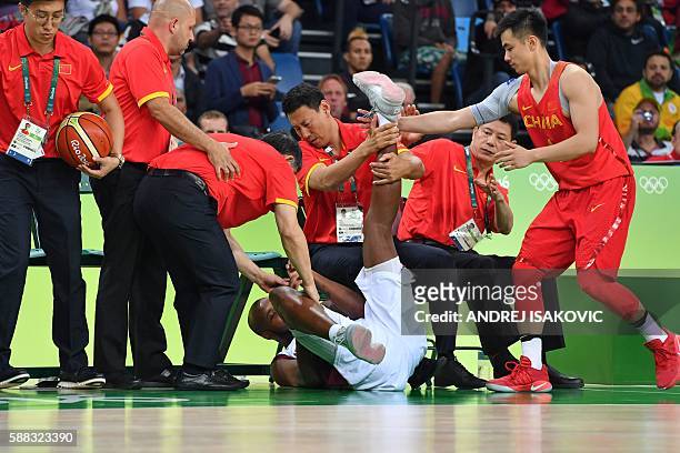 Venezuela's power forward Miguel Ruiz falls below China's bench during a Men's round Group A basketball match between Venezuela and China at the...