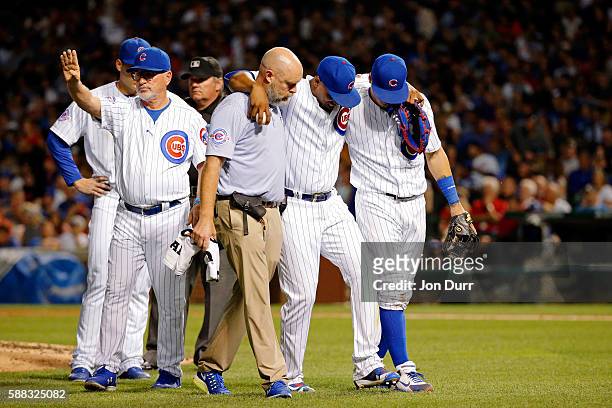 Pedro Strop of the Chicago Cubs is helped off the field after sustaining an apparent injury while fielding a ball against the Los Angeles Angels of...