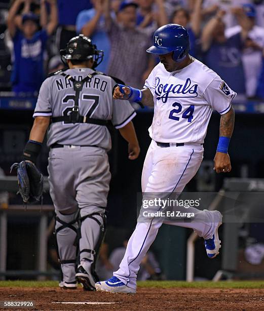 Christian Colon of the Kansas City Royals crosses home past Dioner Navarro of the Chicago White Sox as he scores the game-winning run on a Lorenzo...