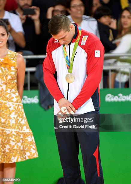 After receiving his under 90kg silver medal, Varlam Liparteliani of Georgia stands with bowed head during the medal ceremony during day 5 of the 2016...