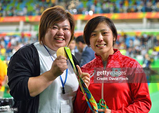 Under 63kg gold medalist, Haruka Tachimoto, right, stands alongside elder sister Megumi Tachimoto, after the medal ceremony on day 5 of the 2016 Rio...