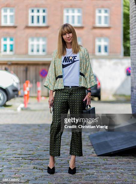 Lisa Aiken wearing a jacket, a white Nike tshirt, green pants, a black bag and heels outside Revolver Fair during the first day of the Copenhagen...