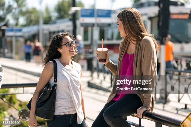 two young female professionals having a fun conversation - ov finance review stockfoto's en -beelden