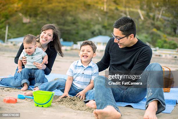 schöne junge ethnische spielen im sand an einem strand - fat guy on beach stock-fotos und bilder