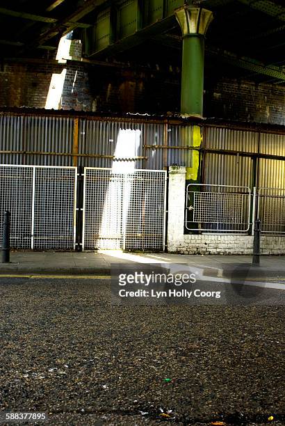 road under railway bridge lit by sunlight - lyn holly coorg stockfoto's en -beelden