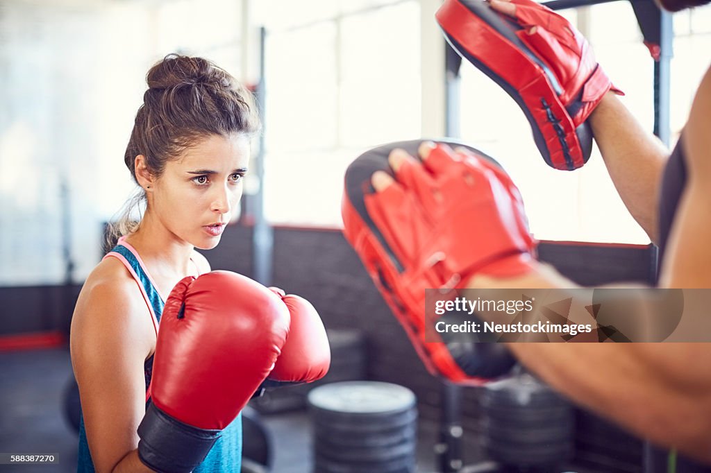 Determined female fit boxer practicing in gym