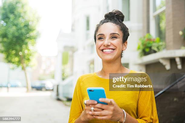 happy woman with smart phone on street. - cell 個照片及圖片檔