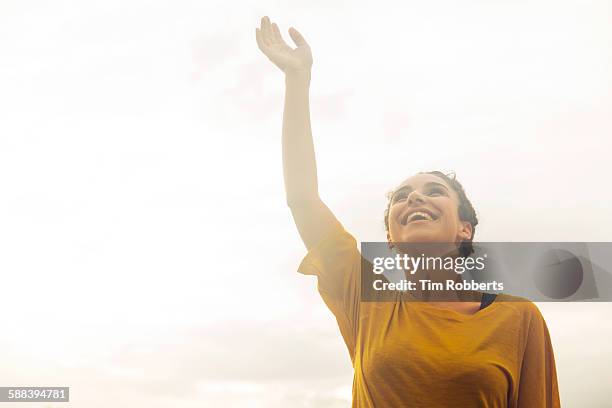 woman with hand in the air. - air waves stockfoto's en -beelden