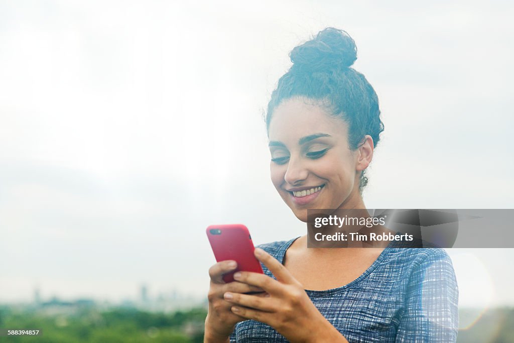 Woman using smart phone smiling.