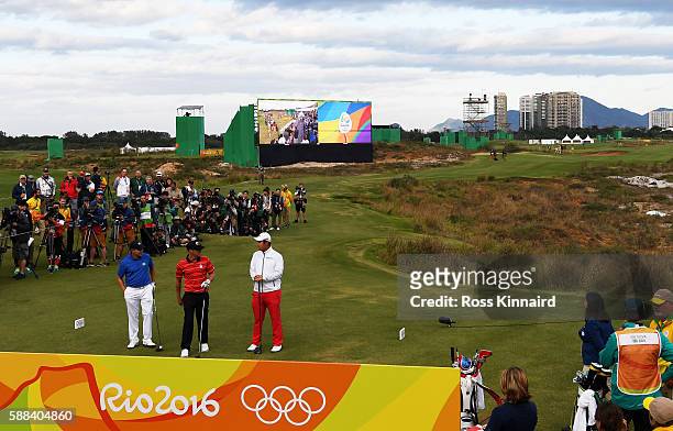 Adilson da Silva of Brazil, Graham Delaet of Canada, and Byeong Hun An of Korea prepare to play from the first tee during the first round of men's...