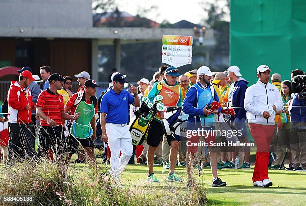 Adilson da Silva of Brazil, Graham Delaet of Canada, and Byeong Hun An of Korea walk from the first tee during the first round of men's golf on Day 6...