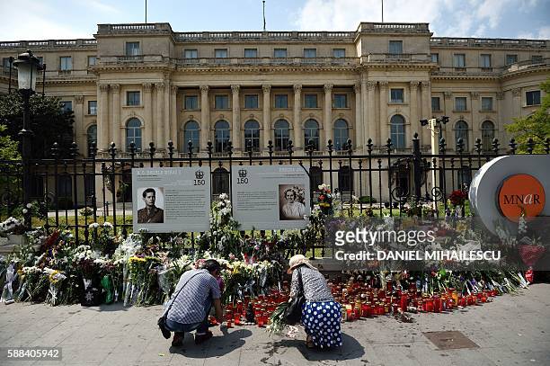 People lay flowers and light candles in the memory of the late Queen Anne of Romania at the Royal Palace, now The Art Museum of Romania, in Bucharest...