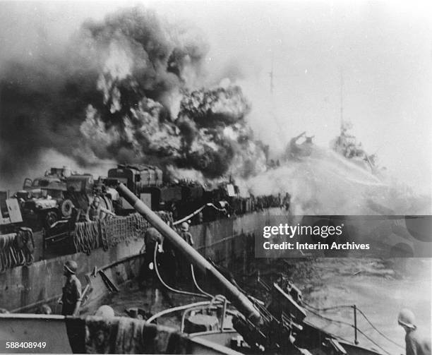 Smoke billows from an American LST as it burns after having been bombed off Mindoro, Philippines, 1944.