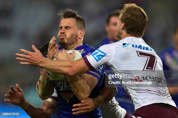 Josh Reynolds of the Bulldogs is tackled during the round 23 NRL match between the Canterbury Bulldogs and the Manly Sea Eagles at ANZ Stadium on...