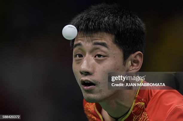 China's Zhang Jike eyes the ball as he serves against Belarus' Vladimir Samsonov in their men's singles semi-final table tennis match at the...