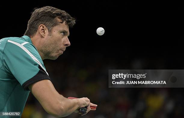 Belarus' Vladimir Samsonov eyes the ball as he serves against China's Zhang Jike in their men's singles semi-final table tennis match at the...