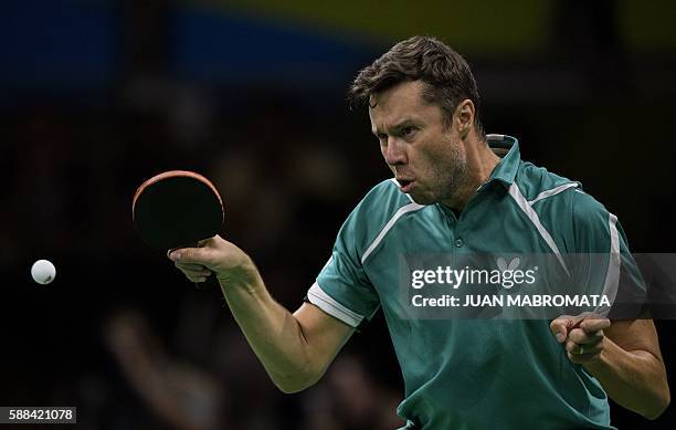 Belarus' Vladimir Samsonov hits a shot against China's Zhang Jike in their men's singles semi-final table tennis match at the Riocentro venue during...