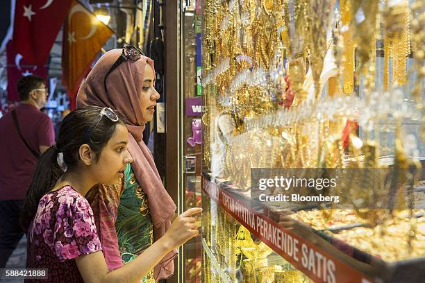 Customers browse gold jewelry in the window of a store in a shopping arcade at the Grand Bazaar in the Sultanahmet district of Istanbul, Turkey, on...