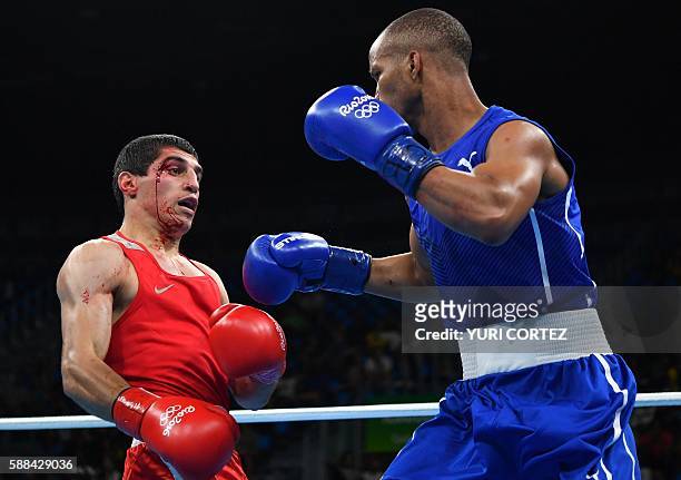 Blood drips down the face of Armenia's Vladimir Margaryan as he fights Cuba's Roniel Iglesias during the Men's Welter match at the Rio 2016 Olympic...