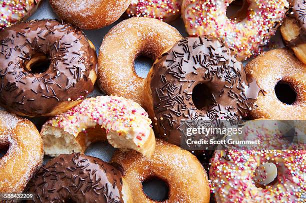 ring doughnuts covered in icing and sprinkes - powdered sugar stock pictures, royalty-free photos & images