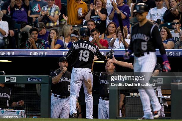 Charlie Blackmon of the Colorado Rockies is congratulated by manager Walt Weiss after scoring a run in the sixth inning as ""h5 prepares to bat...