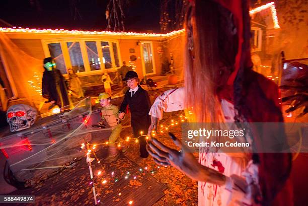 Decker Wendt, left and his friend Carter Bakken right, do some trick or treating as they visit a house in Williston, N.D. Oct 31, 2013. Young...