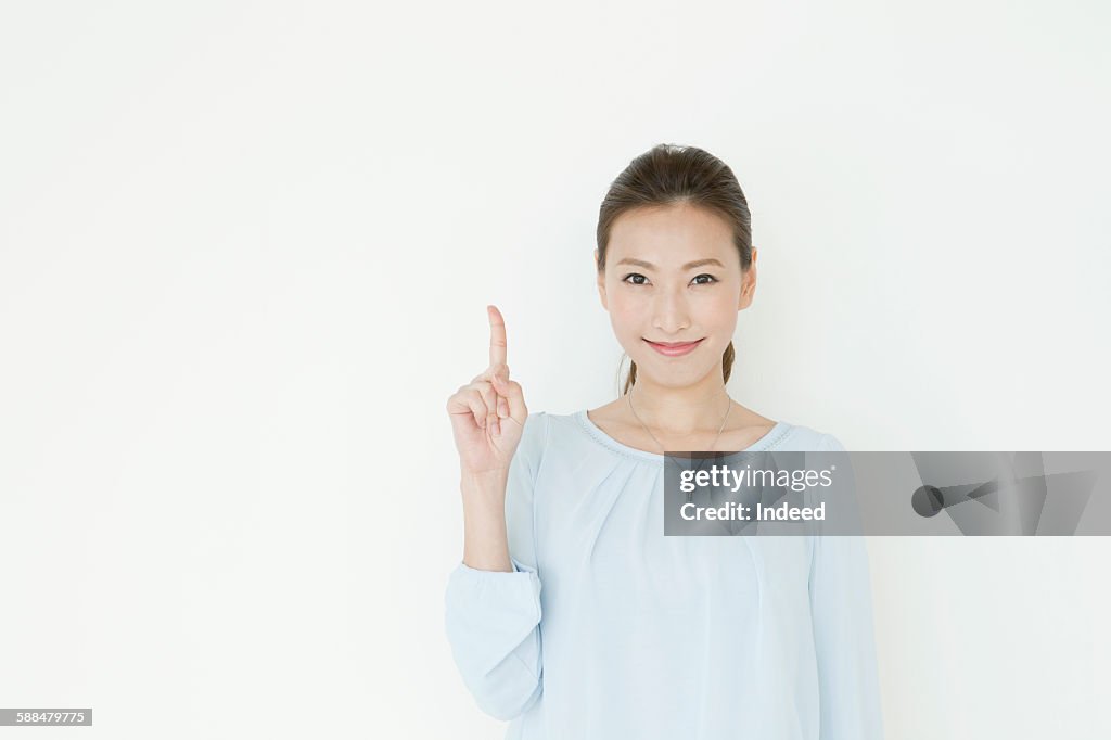 Young woman pointing upward