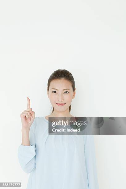 young woman pointing upward - woman index finger stock pictures, royalty-free photos & images