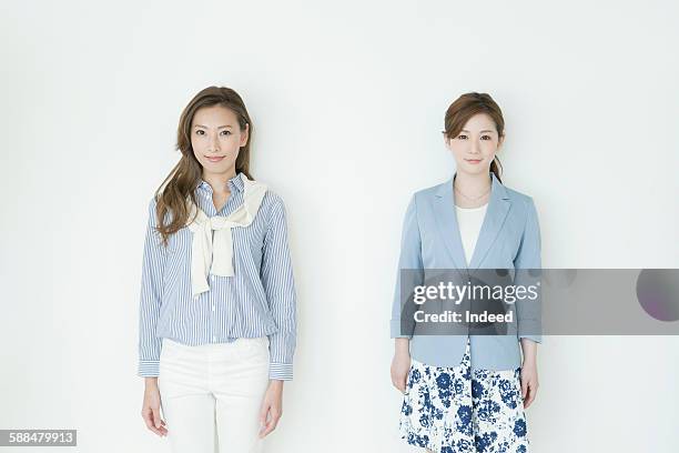young businesswomen standing side by side - side by side stock pictures, royalty-free photos & images