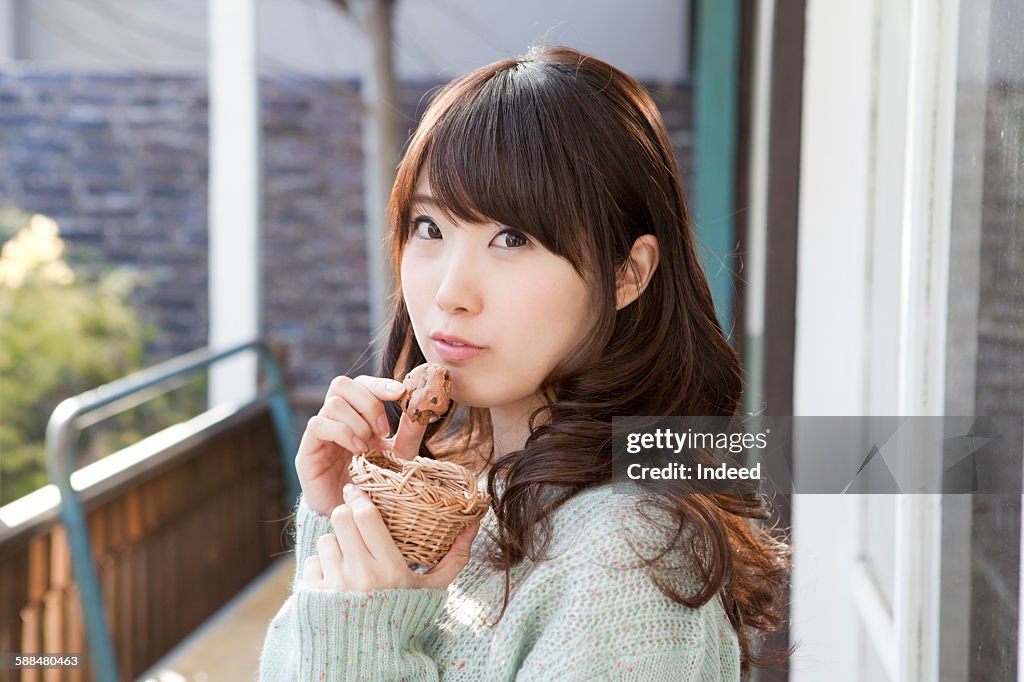 Young woman holding cookie, portrait