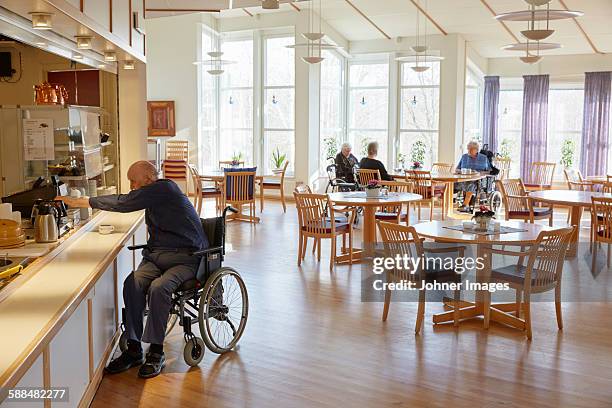 senior man having coffee in dining room - seniorenhuis stockfoto's en -beelden