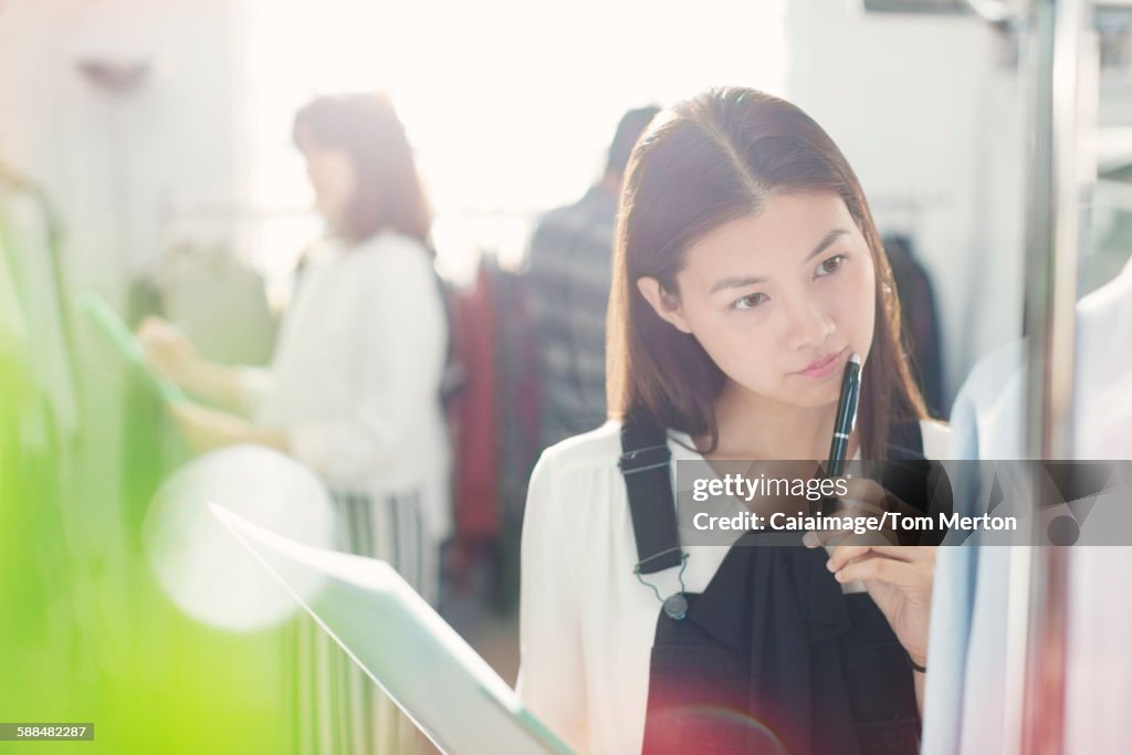 Pensive fashion designer examining shirt