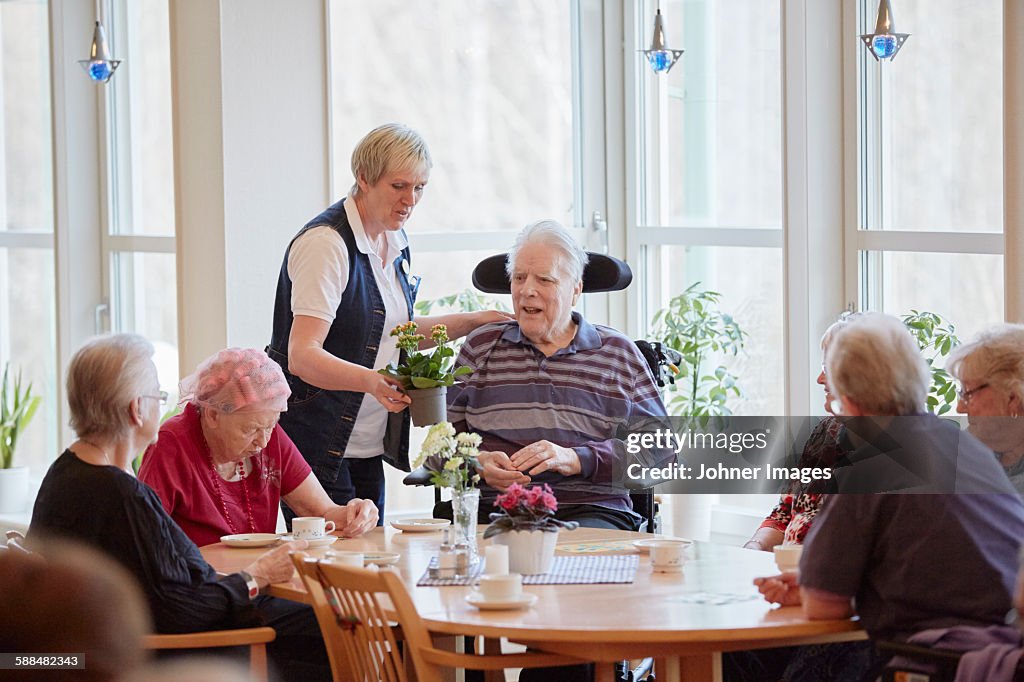 Senior people having coffee in care home