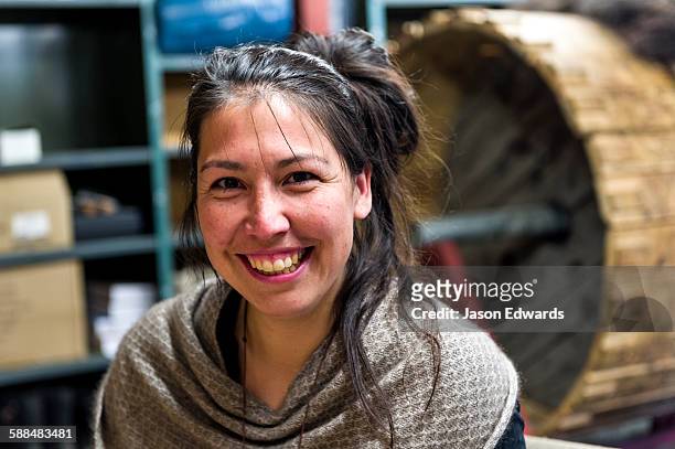 a musk ox jewelry artist smiling in her studio. - inuit people stock-fotos und bilder