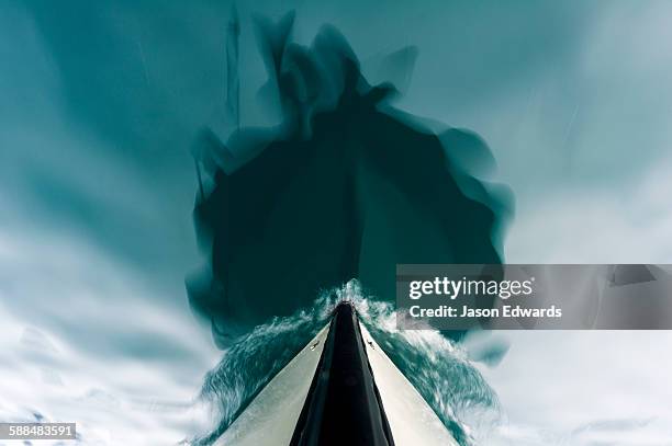 the bow of a boat passing over the still waters of an arctic fjord. - proa fotografías e imágenes de stock