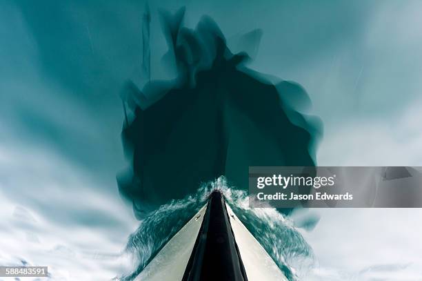 the bow of a boat passing over the still waters of an arctic fjord. - ships bow stock pictures, royalty-free photos & images