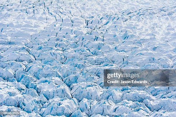 pressure ridges and crevasse scar the surface of a glacier on the greenland ice sheet. - ice sheet stock pictures, royalty-free photos & images