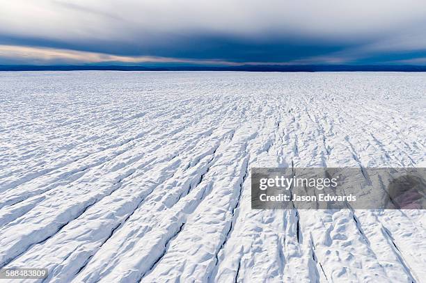 pressure ridges and crevasse scar the surface of a glacier on the greenland ice sheet. - poolkap stockfoto's en -beelden