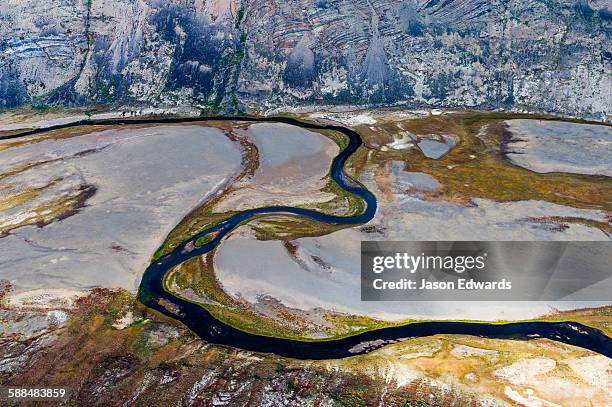 a winding river snakes its way across a highland tundra valley floor. - arctic stock pictures, royalty-free photos & images