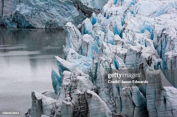 treacherous jagged ice spires on a glacier fracture zone known as serac. - kangerlussuaq stock pictures, royalty-free photos & images