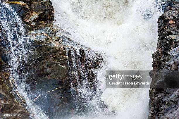 meltwater floods a cascading waterfall at the base of a glacier. - sedimentary stock pictures, royalty-free photos & images