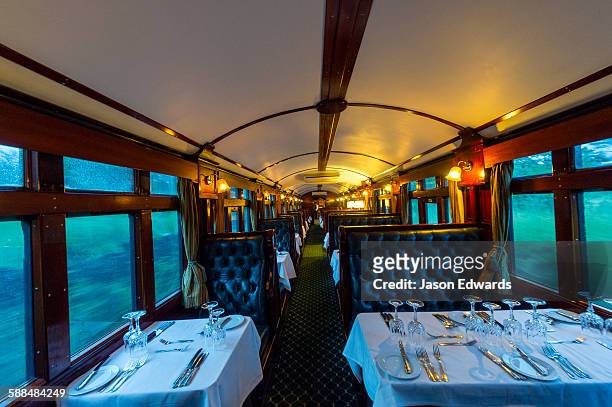 the first class dining car of an antique steam train replete with silver service. - treincoupé stockfoto's en -beelden