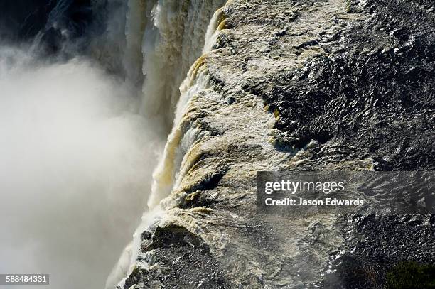 the flooded waters of the zambezi river pour over victoria falls and into the cataract of first gorge. - zambezi river stockfoto's en -beelden