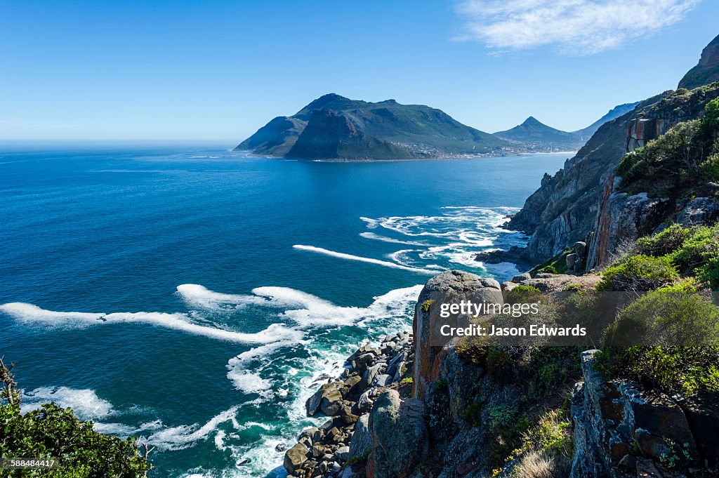 Wave foam trapped in currents along the base of coastal cliffs.
