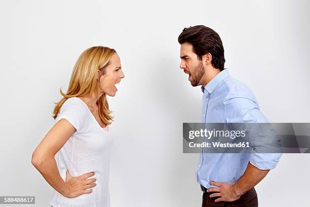 angry couple shouting at each other in front of white background - loud man imagens e fotografias de stock