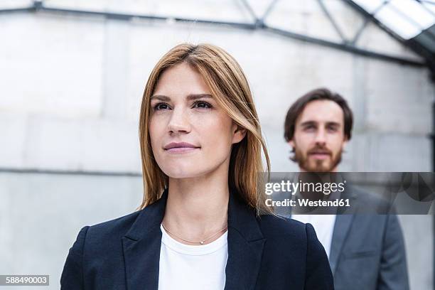 portrait of businesswoman with her partner in the background - well dressed young man stock pictures, royalty-free photos & images