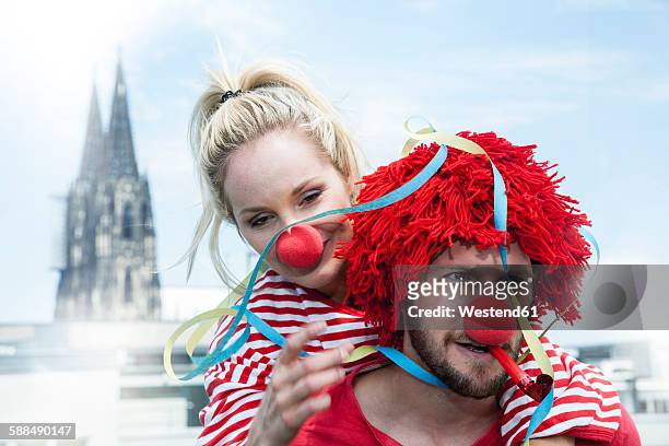 germany, cologne, young couple celebrating carnival dressed up as clowns - fiesta stock-fotos und bilder