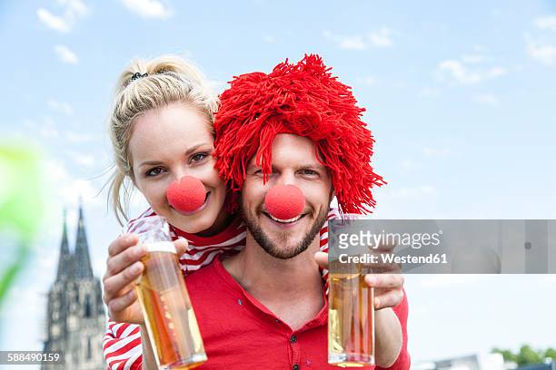 germany, cologne, young couple celebrating carnival dressed up as clowns - clownsneus stockfoto's en -beelden