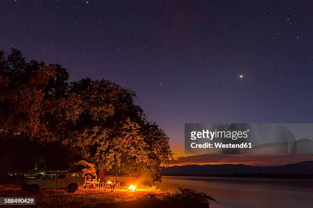zimbabwe, urungwe district, mana pools national park, camp fire at riverside of zambezi at night - zambezi river stockfoto's en -beelden